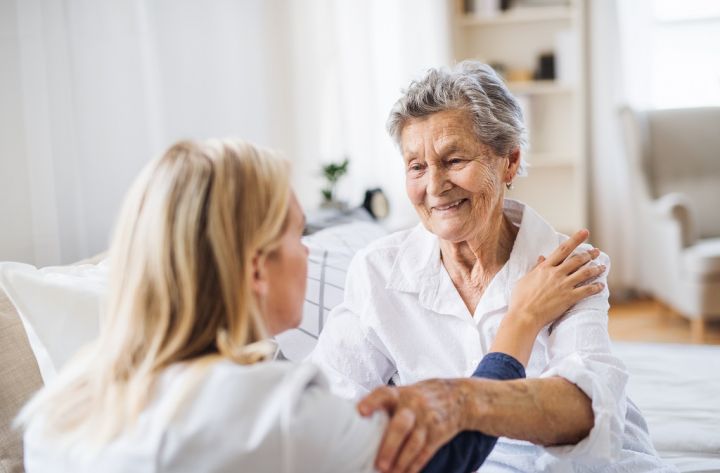 a-health-visitor-talking-to-a-sick-senior-woman-F64BTVD.jpg