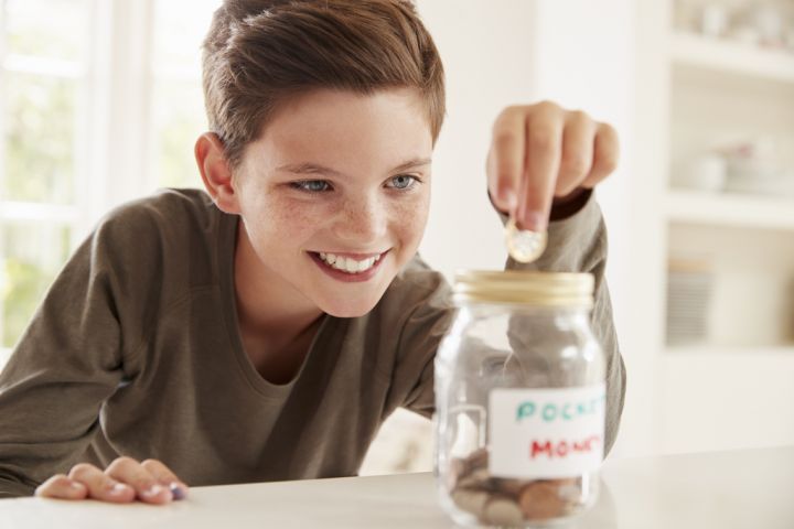 boy-saving-pocket-money-in-glass-jar-at-home-PXW6UN9.jpg