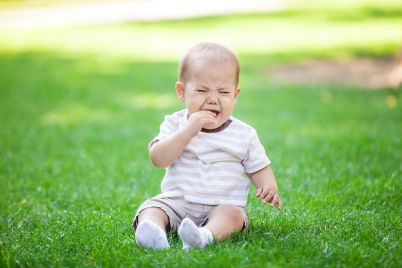 little-boy-crying-while-sitting-on-grass-in-park-PYA3WDY.jpg
