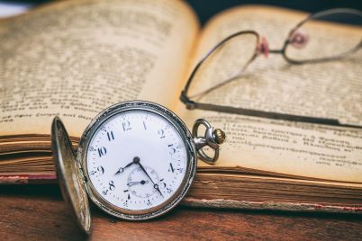 pocket-watch-and-eye-glasses-on-an-old-book-PEZN6FM.jpg
