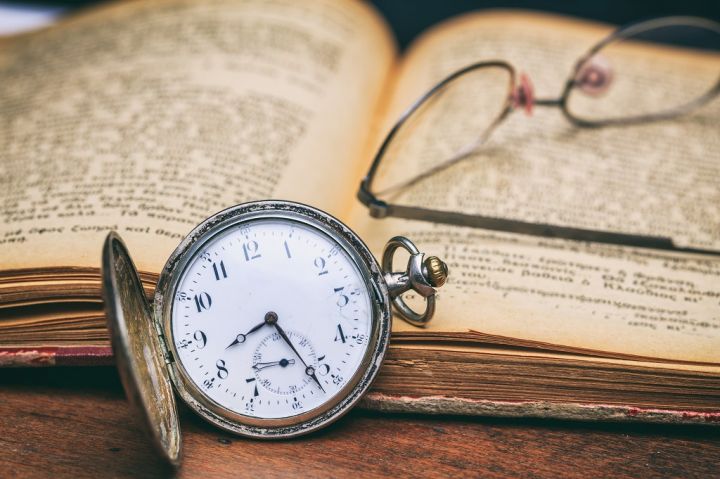 pocket-watch-and-eye-glasses-on-an-old-book-PEZN6FM.jpg