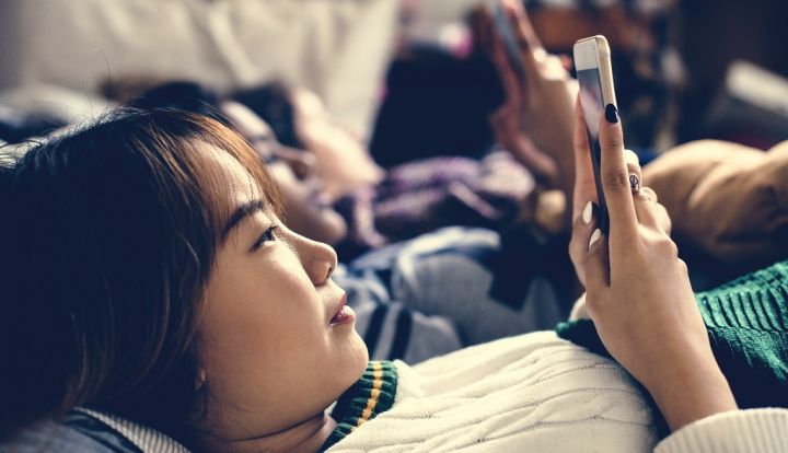 teenage-girls-using-smartphones-on-a-bed-internet-FYQAHRD.jpg