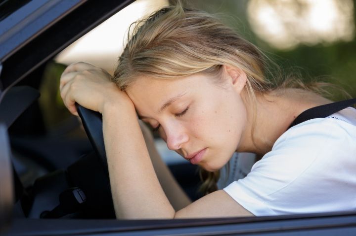 tired-woman-sleep-in-car-PUUYKMT.jpg