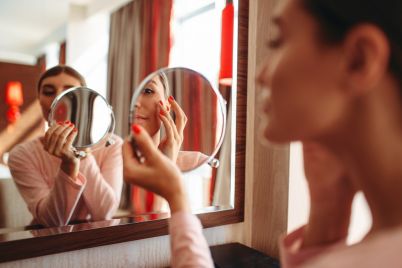 woman-doing-makeup-at-the-mirror-face-hygiene-R25DH6N.jpg